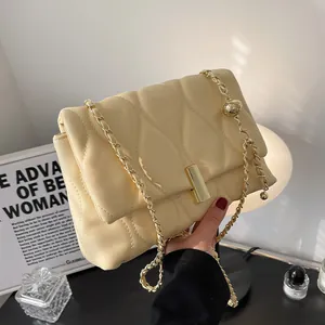Beige quilted leather crossbody bag with gold chain strap and metal ball adjuster