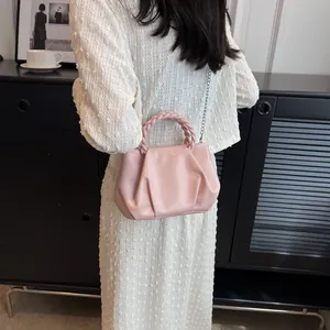 Rosa geraffte Cloud-Tasche mit geflochtenem Griff und silberner Kette am Modell