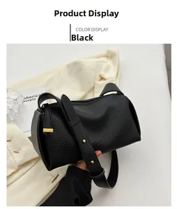 Detail of black lychee grain leather crossbody bag with gold rivet strap and hardware