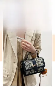 Detail of vintage flap handbag with logo pattern, metal lock, and plush doll charm