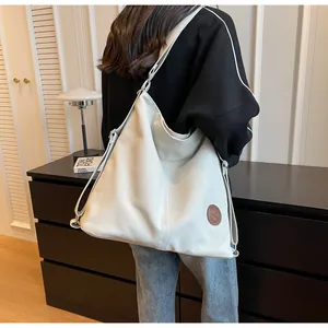 Detail view of large grey canvas tote bag with adjustable strap worn by a model