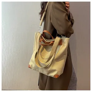 Detail of canvas tote bag with brown leather trim and reinforced bottom corners