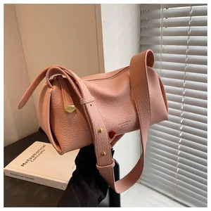 Detailed macro of pink cylinder bucket bag with lychee texture and heart charm