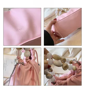 Close-up of pink ruched cloud bag featuring marble beads and silver chain details