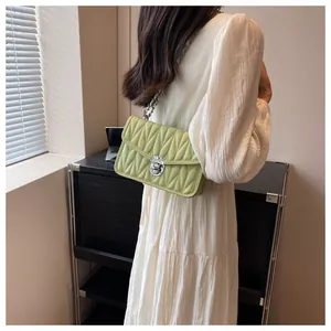 Detail of light green pleated shoulder bag with silver chain and metal twist lock