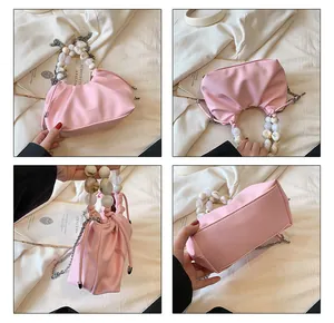 Detailed views of pink pleated handbag with amber bead handle and silver chain strap
