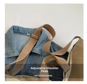 Close-up of the adjustable woven shoulder strap with metal buckle on khaki canvas bag