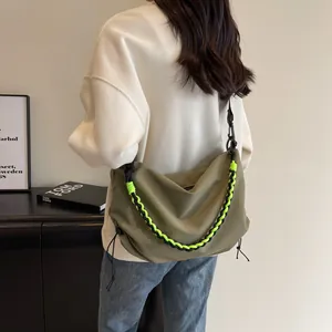 Minimalist green dumpling bag for women with a stylish woven crossbody strap