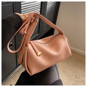 Detail showing pink lychee grain leather Boston bag with wide strap and gold hardware