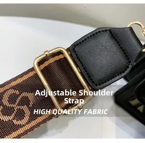 Macro shot of adjustable woven shoulder strap with retro pattern and gold metal buckle