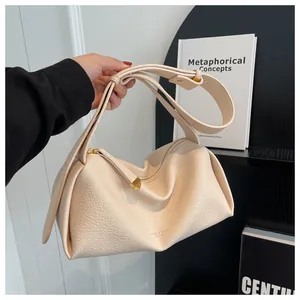 Detail of soft cream leather crossbody bag with litchi texture and wide adjustable strap