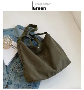 Detail view of the green canvas tote bag featuring a secure metal snap button closure