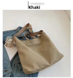 Detail view of khaki canvas tote bag with adjustable shoulder strap and snap button closure