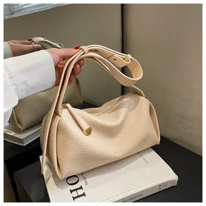 Macro detail of creamy leather texture and gold-tone zipper on stylish crossbody bag