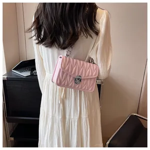 Rear view of pink pleated chain bag with silver twist lock shown on a female model