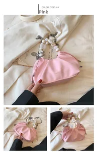 Detail of pink pleated handbag featuring a marble bead handle and silver chain strap