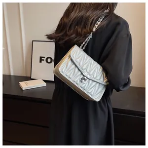 Silver quilted chain bag shown on a model in a modern minimalist indoor setting