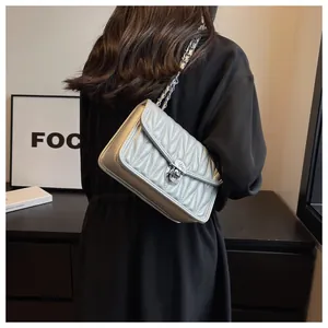 Silver quilted chain bag detail with textured ruffle pattern and metallic twist lock