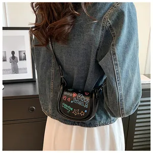 Détail d'un mini sac besace noir avec des graffitis street art colorés sur le rabat