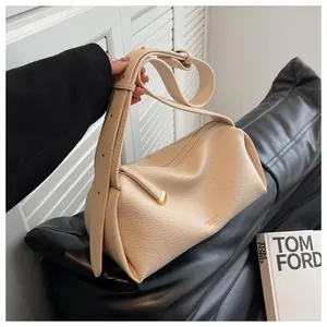 Detail of beige lychee grain leather bag showing wide strap and gold zipper hardware