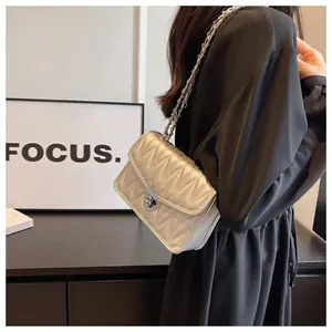 Silver quilted chain bag detail showing V-shaped texture and metallic turn-lock closure