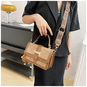 Classic brown monogram flap handbag with wide patterned strap and plush charm detail