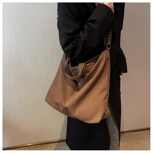 Brown canvas hobo tote bag detail with dual handles and wide shoulder strap style