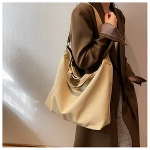 Khaki canvas tote bag shown styled with a trench coat for a casual autumn look