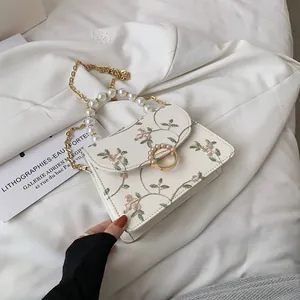 Elegant white lace embroidered crossbody bag with pearl handle and golden chain strap