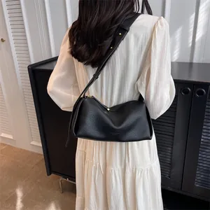 Women's black litchi pattern crossbody bag with wide strap and gold hardware