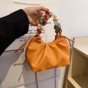 Orange pleated leather handbag with colorful resin bead handle and silver chain strap