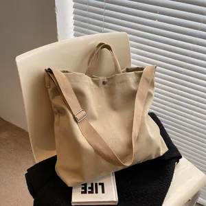 Minimalist khaki large capacity canvas tote bag with adjustable shoulder strap on a chair