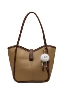 Minimalist khaki tote bag with wavy edges and a cute white plush monster charm
