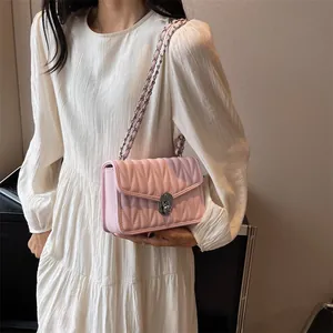 Pale pink quilted crossbody bag with silver chain strap and metal lock closure