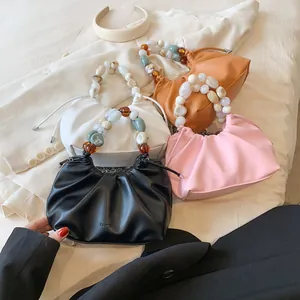 Ruched pleated handbags with pearl bead handles in black, pink, white, and tan colors