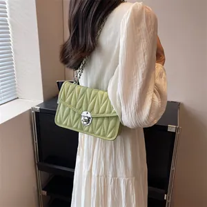 Light green quilted crossbody bag with matelasse stitching and metal chain strap
