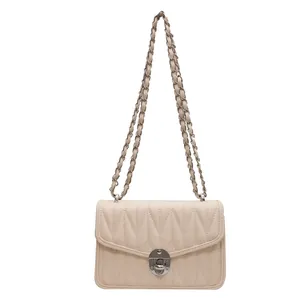 Quilted beige crossbody chain bag with V-shaped stitching and golden twist lock