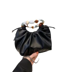 Fashionable black pleated leather handbag with decorative multicolored beaded pearl handle