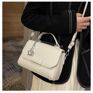Detailed view of white litchi pattern leather handbag with elegant swan metal charm detail