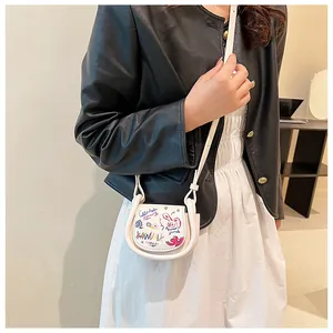 Gros plan du mini sac selle blanc avec graffitis artistiques et bandoulière fine