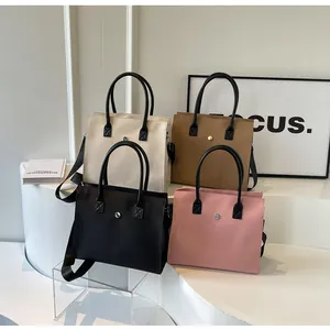 Detail view of large tote bags in black, white, khaki, and pink with adjustable straps