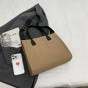 Macro shot of khaki tote bag with magnetic metal clasp and reinforced black handles