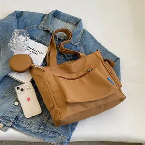 Detail of khaki canvas tote bag with mini pouch, side pocket and front zipper storage