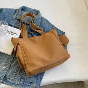 Detail of canvas tote bag with side pockets and a round coin purse on denim jacket