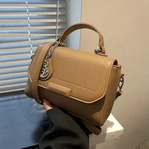 Classic tan leather handbag with lychee texture and silver bird charm detail
