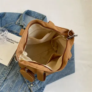 Large khaki canvas tote bag with internal compartments and a detachable round coin purse