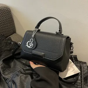 Chic black litchi pattern handbag with silver swan charm and adjustable strap