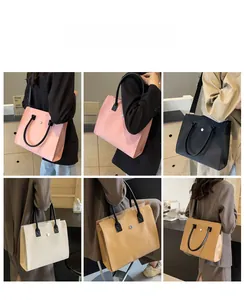 Detail view of large tote bags in pink, black, and beige with metallic buckle closure