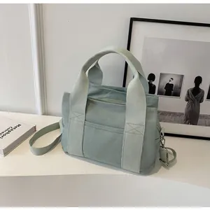 Close-up of mint green canvas tote bag with reinforced X-stitching and adjustable strap