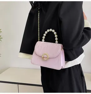 Detail of pink marble pattern handbag featuring pearl handle and gold chain strap